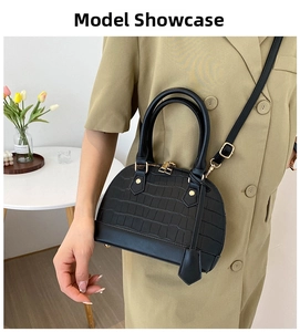 Classic black shell bag with stone texture showing scale on a shoulder strap model