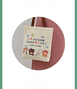 Detail of cream canvas tote bag with colorful cartoon animals and brown handles