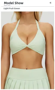 Detailed view of light green halter yoga bra and pleated skirt on a fitness model