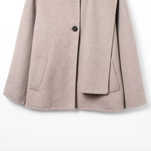 Close-up of light camel wool coat featuring a single button and functional side pocket