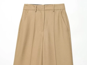 Detailed close-up of khaki slim-fit trousers showing waist button and twill fabric texture