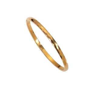 Polished 18k gold plated stainless steel bangle with elegant diamond-cut texture pattern