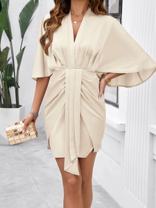 Elegant beige V-neck dress with batwing sleeves and wrap front waist detailing