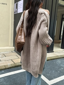 Vista street style di un lungo cardigan in maglia grossa beige su una modella di spalle