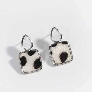 Close-up of square leopard print earrings with silver frame and white drop detail