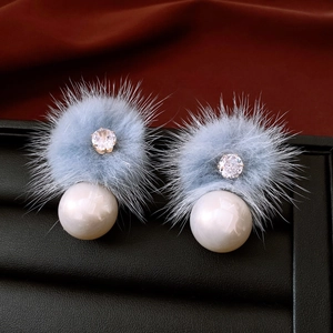 Dettaglio orecchini a pompon azzurro con perla bianca e cristallo scintillante