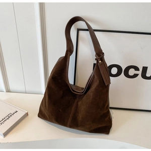 Detail of soft brown suede texture on vintage hobo shoulder bag with a minimalist tag