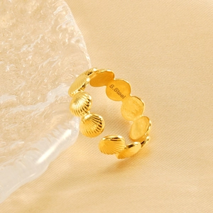 Adjustable golden stainless steel shell ring displayed on silk with water ripple glass