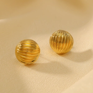 Textured 18k gold plated spherical stud earrings on beige silk background