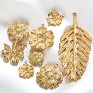 18K gold plated stainless steel sunflower and palm leaf charms on white satin background