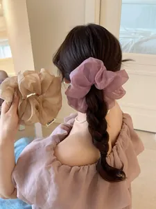 Dettaglio di eleganti elastici in organza viola e beige con texture plissettata