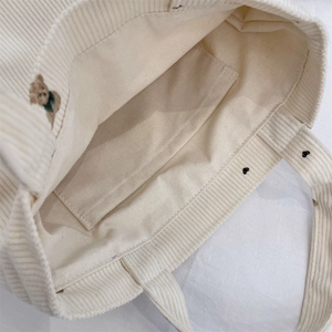 Detail view of corduroy tote bag interior featuring an open pocket and soft texture