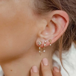Elegant gold S925 silver fringe earrings set with zircon flowers on a female model