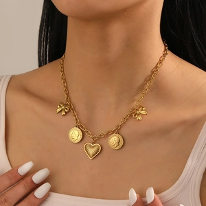 Detail of vintage gold-plated O-chain necklace with heart and coin pendants on neck