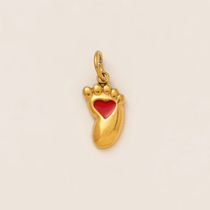 Vue rapprochée du pendentif empreinte doré avec cœur rouge sur fond blanc