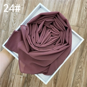 Gros plan d'un châle en mousseline vieux rose avec texture fine plié en fleur