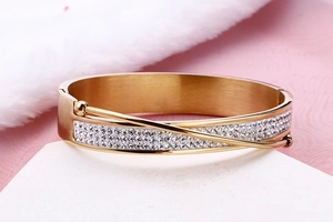 Detailed view of a gold-plated wide cuff bracelet with multiple rows of sparkling crystals