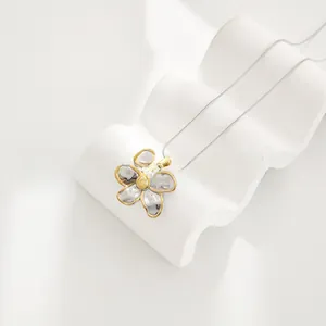 Detailed macro view of dual-tone flower pendant with hammered texture and white pearl center
