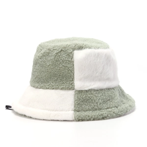 Close-up of sage green and cream plush faux fur patchwork bucket hat texture