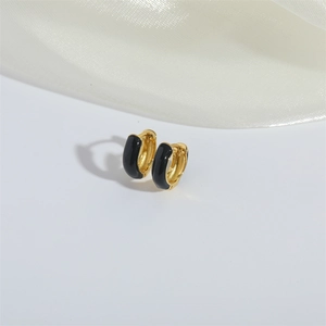 Elegant gold-plated hoop earrings with black enamel inlay set on a white silk fabric