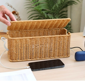 Detail of hand opening an imitation rattan cable box for desktop wire management