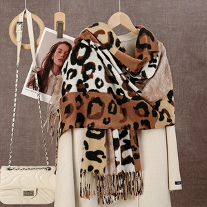 Détail d'une écharpe léopard avec franges douces sur un manteau d'automne beige classique