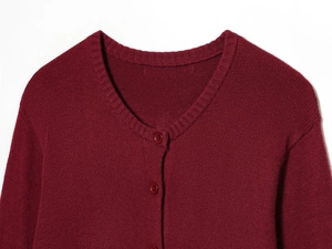 Gros plan détaillé du col et des boutons du cardigan en tricot bordeaux doux
