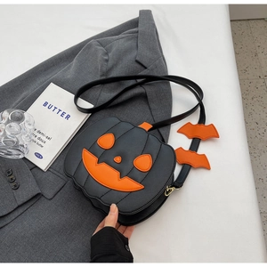 Detail of Halloween pumpkin crossbody bag with orange bat wings on a charcoal grey suit