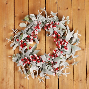 Christmas wreath with red berries and snowy eucalyptus leaves on wooden background