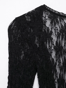 Close-up of intricate black lace patterns and delicate embroidery on the neckline