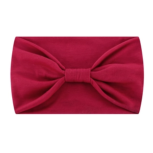 Detail of burgundy elastic headband showing knot design and soft knit texture