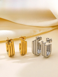 Detail of minimalist triple-layered U-shaped earrings in polished gold and silver finish