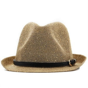 Detailed view of straw fedora hat featuring metallic gold weave and black leather strap
