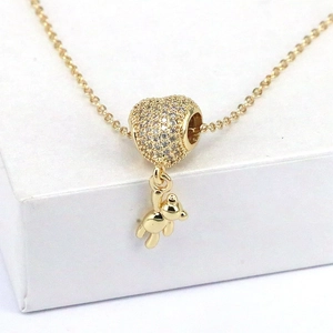Cute gold bear necklace with sparkling zircon heart pendant on white jewelry box