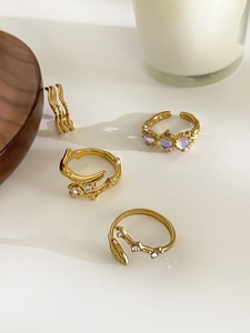 Flat lay of gold plated rings featuring lava texture, amethyst stones and leaf details