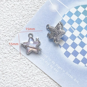 Macro shot of 15mm silver star charms with purple enamel and sparkling zircon inlay
