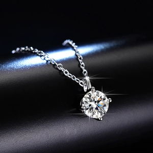 Close-up of a brilliant-cut moissanite pendant with a classic four-prong silver setting