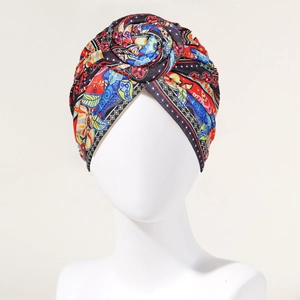 Detail of bohemian turban hat featuring a red floral knot and vintage ethnic print