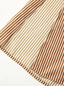Detailed macro view of brown and white striped fabric texture with rolled hem stitching