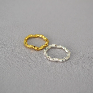 Draufsicht auf zwei minimalistische gehämmerte Wellenringe in Gold und Silber