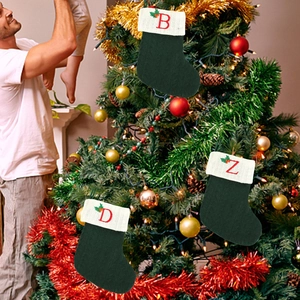 Chaussettes de Noël en tricot vert avec broderie rouge sur un sapin de Noël festif