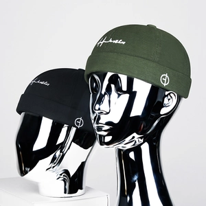 Bonnet miki streetwear brodé en noir et vert armée sur un fond gris neutre