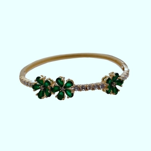 Elegant gold open bangle featuring green clover flower petals with sparkling zircon accents
