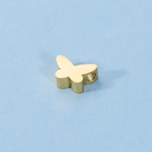 Close-up of golden butterfly pendant bead with smooth mirror finish and hole detail