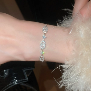 Makroaufnahme von Silberarmband mit Zirkonia-Pavé und verschlungenen Gliedern am Handgelenk