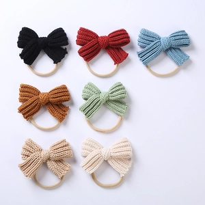 Macro detail of soft knitted bow headbands in seven colors on elastic nylon bands