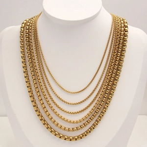 Golden stainless steel box chains in seven different widths displayed on a white neck model