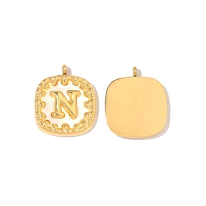 Dettaglio di un ciondolo quadrato in oro 14k con conchiglia e lettera N in rilievo