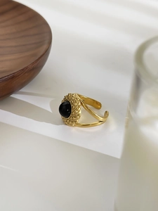 Detailed macro view of 18K gold-plated hammered ring featuring an oval black gemstone