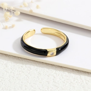 Detailed close-up of a 18K gold plated ring with black enamel and a micro-set zircon stone